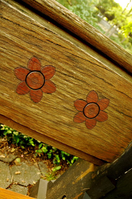 carved red flowers on a wooden bench